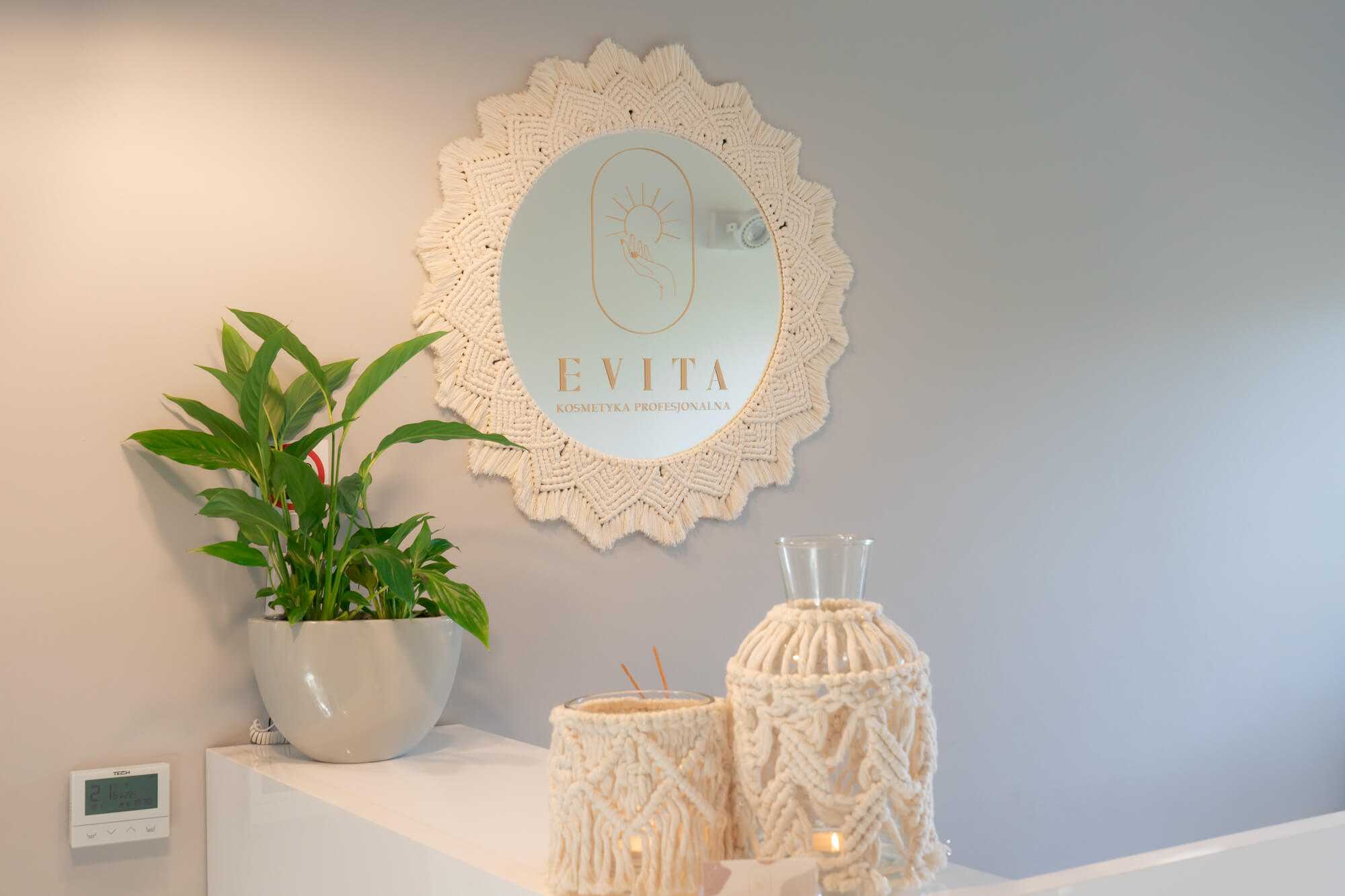 Makramowe lustro ze złotym logo Salonu Kosmetyki Profesjonalnej „Evita” w recepcji salonu