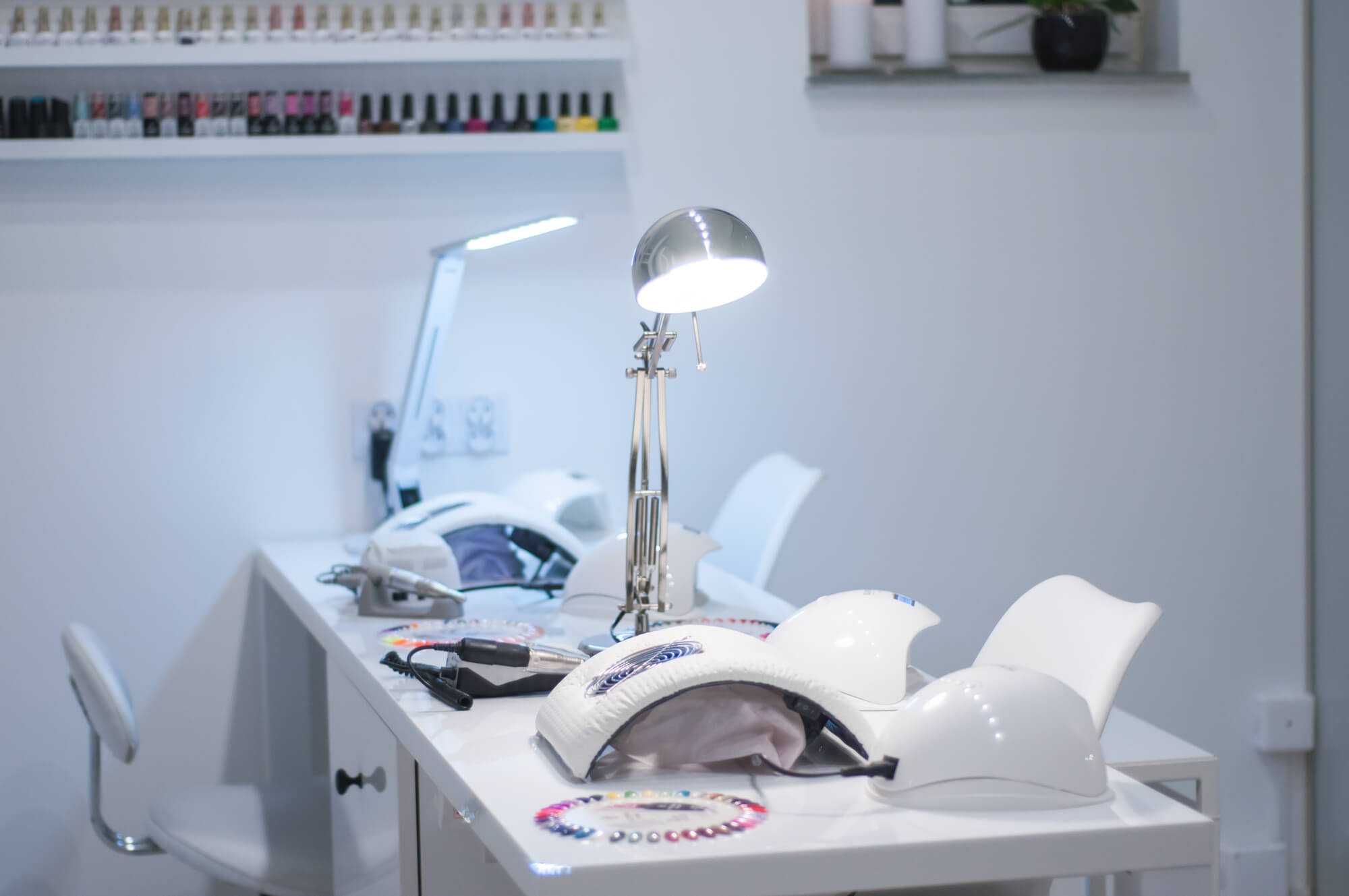 Lampy do manicure hybrydowego, wzorniki lakierów i półka z lakierami w Salonie „Evita”